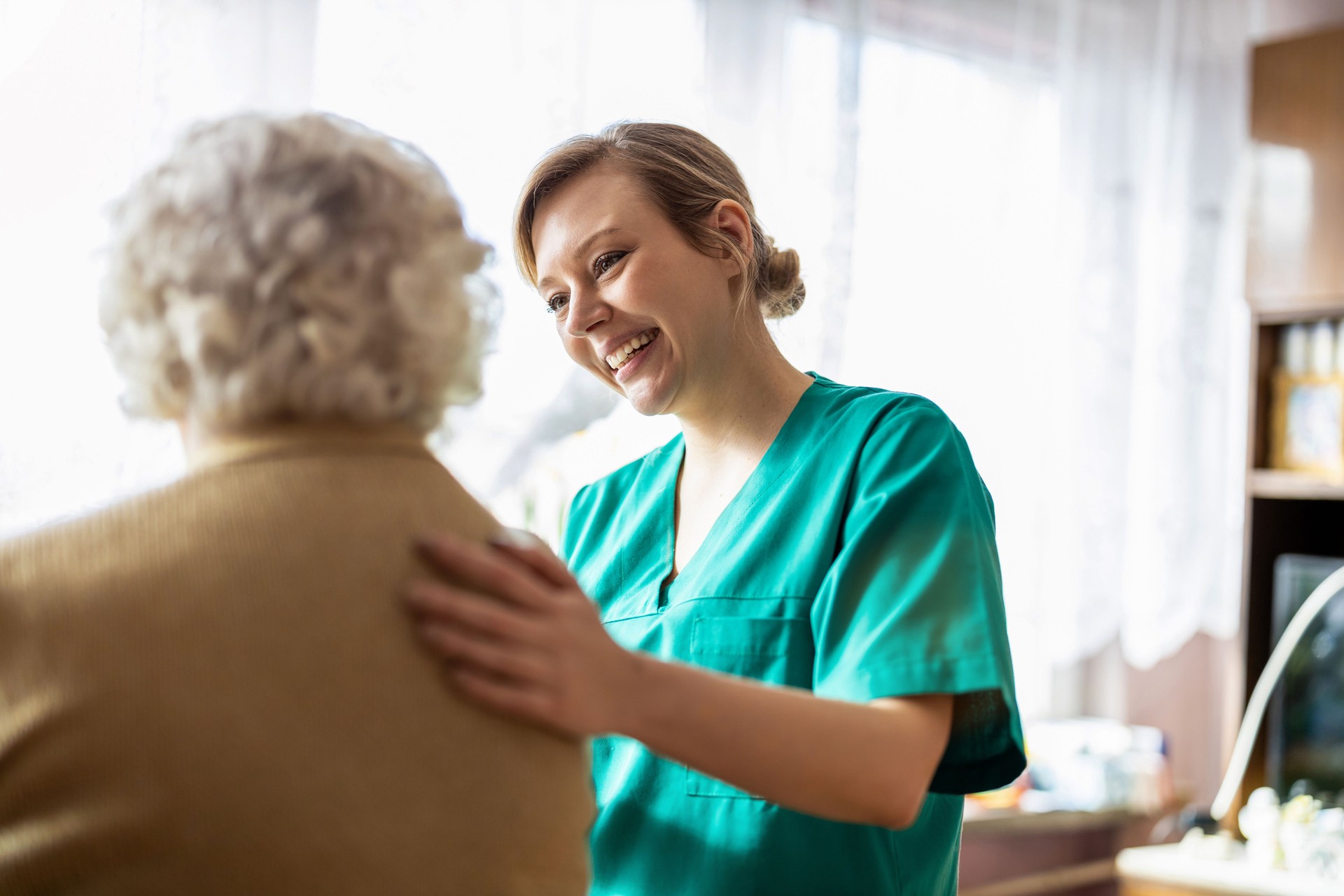 Friendly nurse supporting an elderly lady